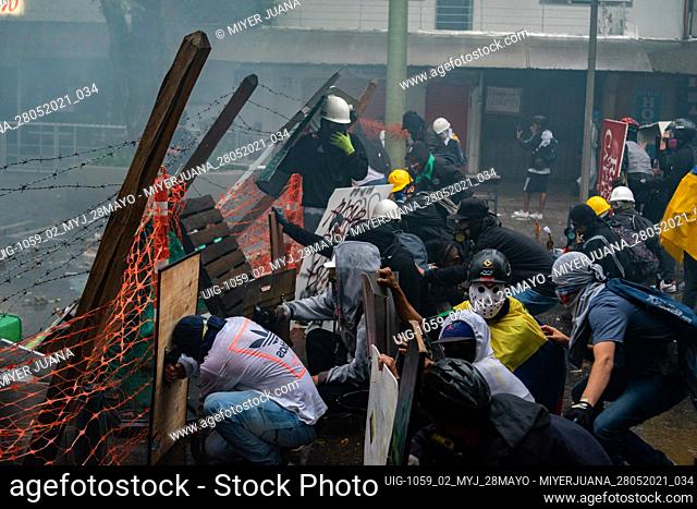 Members of the front line of defense barricade a riot armored truck from Colombia's riot Police (ESMAD) as people protest in an anti government protest against...